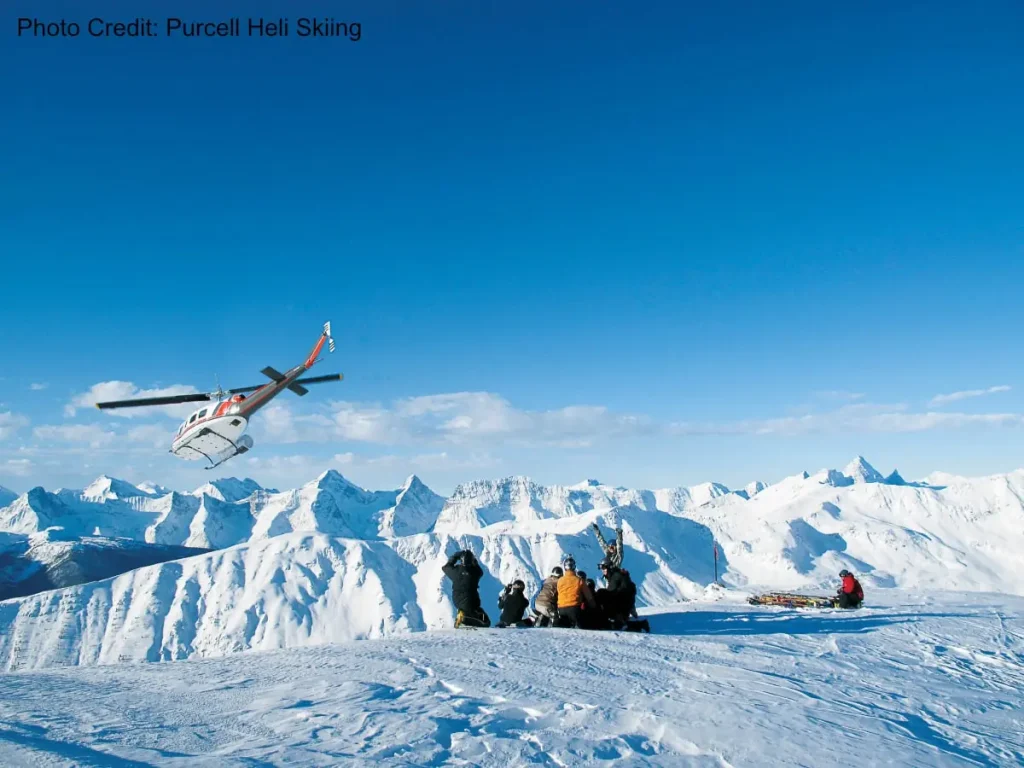 helicopter taking off after dropping skiers atop a peak near Kicking Horse resort