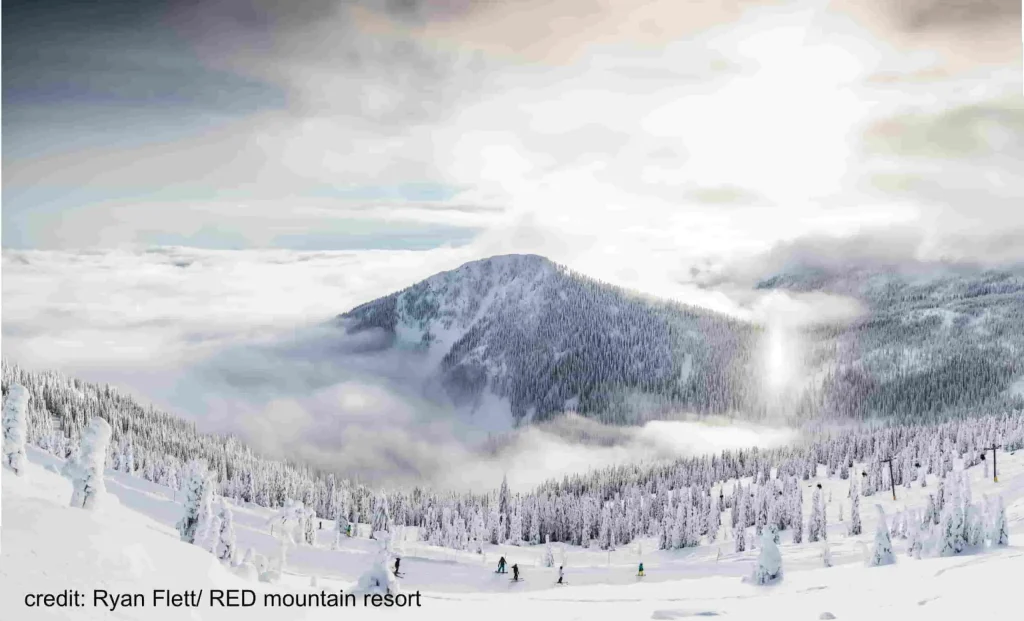 skiers descending on an overcast day at Red Mountain Ski Resort