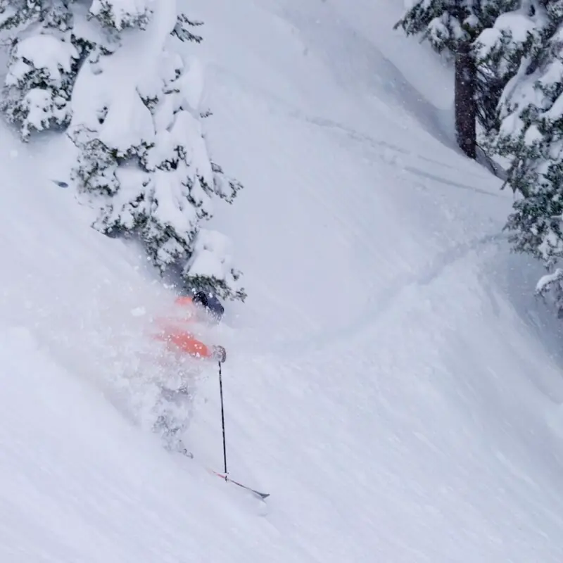 skier kicking up powder on a steep slope at Revelstoke resort