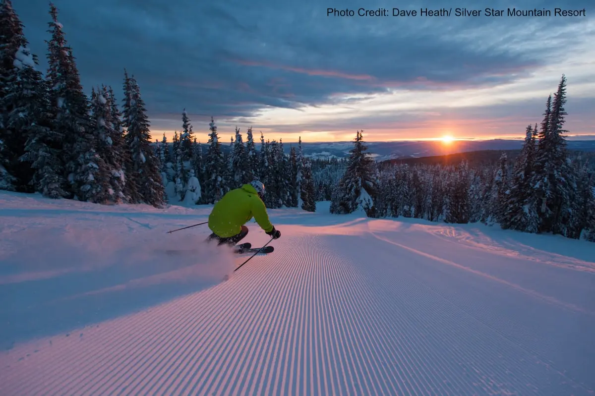 skier on a groomed run at sunset in Silver Star resort