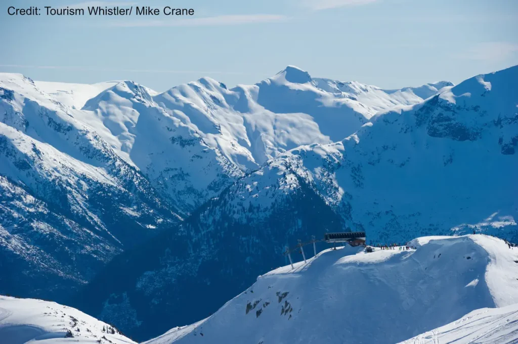 view of the top of a chairlift overlooking snowy peaks at Whistler