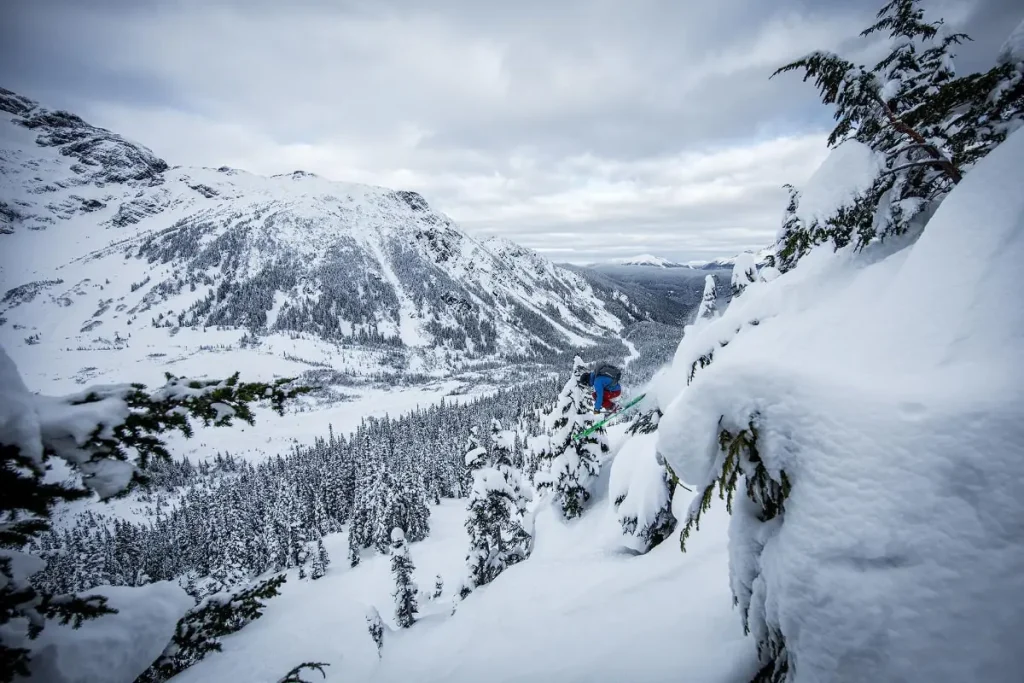 skier going off big drop in Skeena Bearclaw lodge backcountry