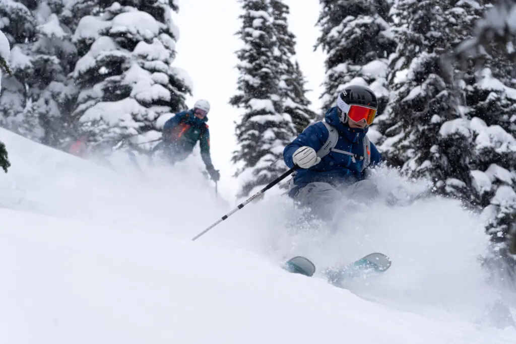 skiers in the trees at White Grizzly lodge