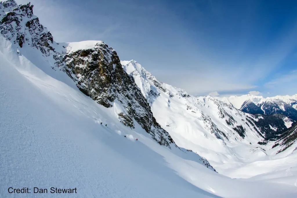 skiers descending steep powder in Revelstoke