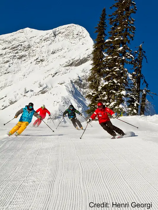 group of skiers on a groomed run