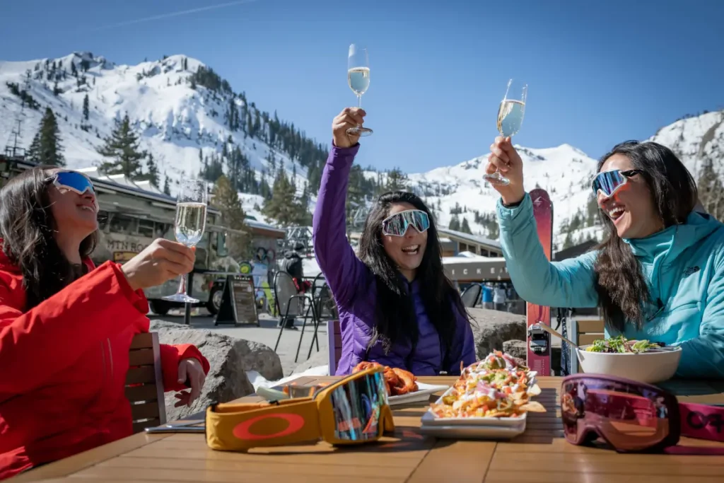 women raising a glass of wine on a sunny day in Palisades ski resort