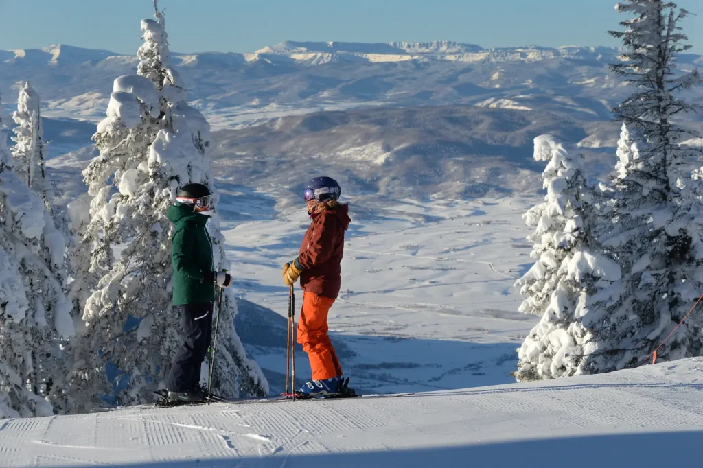 2 skiers atop a run at Steamboat Springs ski resort