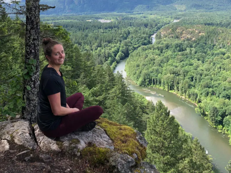 Hanne sitting atop a cliff overlooking a river