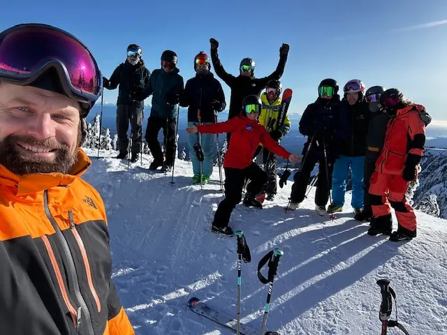 Tobin taking a selfie in front of a group of skiers